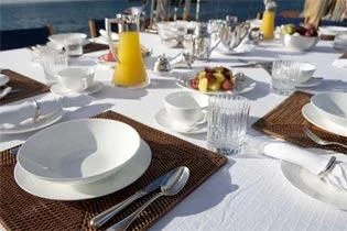 a table with plates and glasses aboard ELEONORA E Yacht for Sale