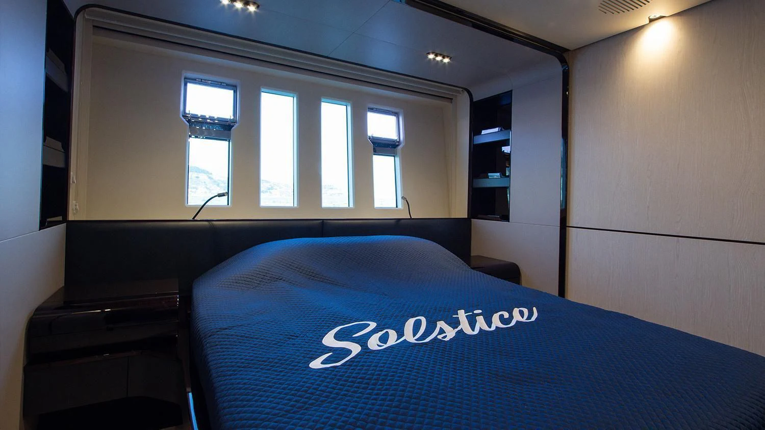 a bed with blue sheets aboard SOLSTICE Yacht for Sale