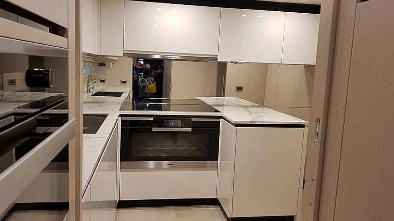 a kitchen with white cabinets aboard SOLSTICE Yacht for Sale