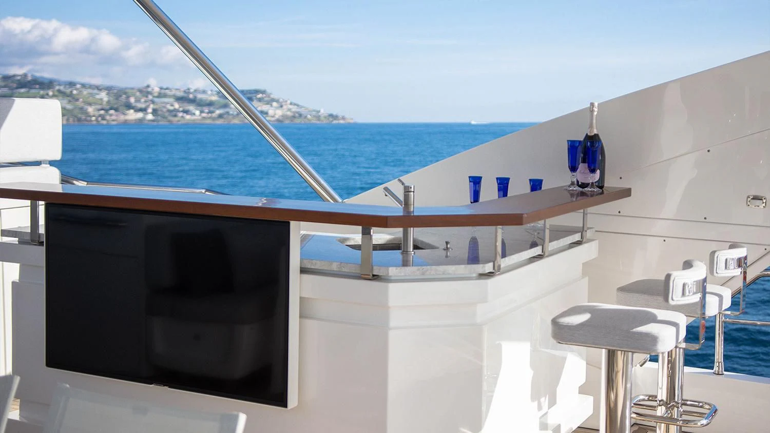 a deck with a large body of water and a large ship in the background aboard SOLSTICE Yacht for Sale