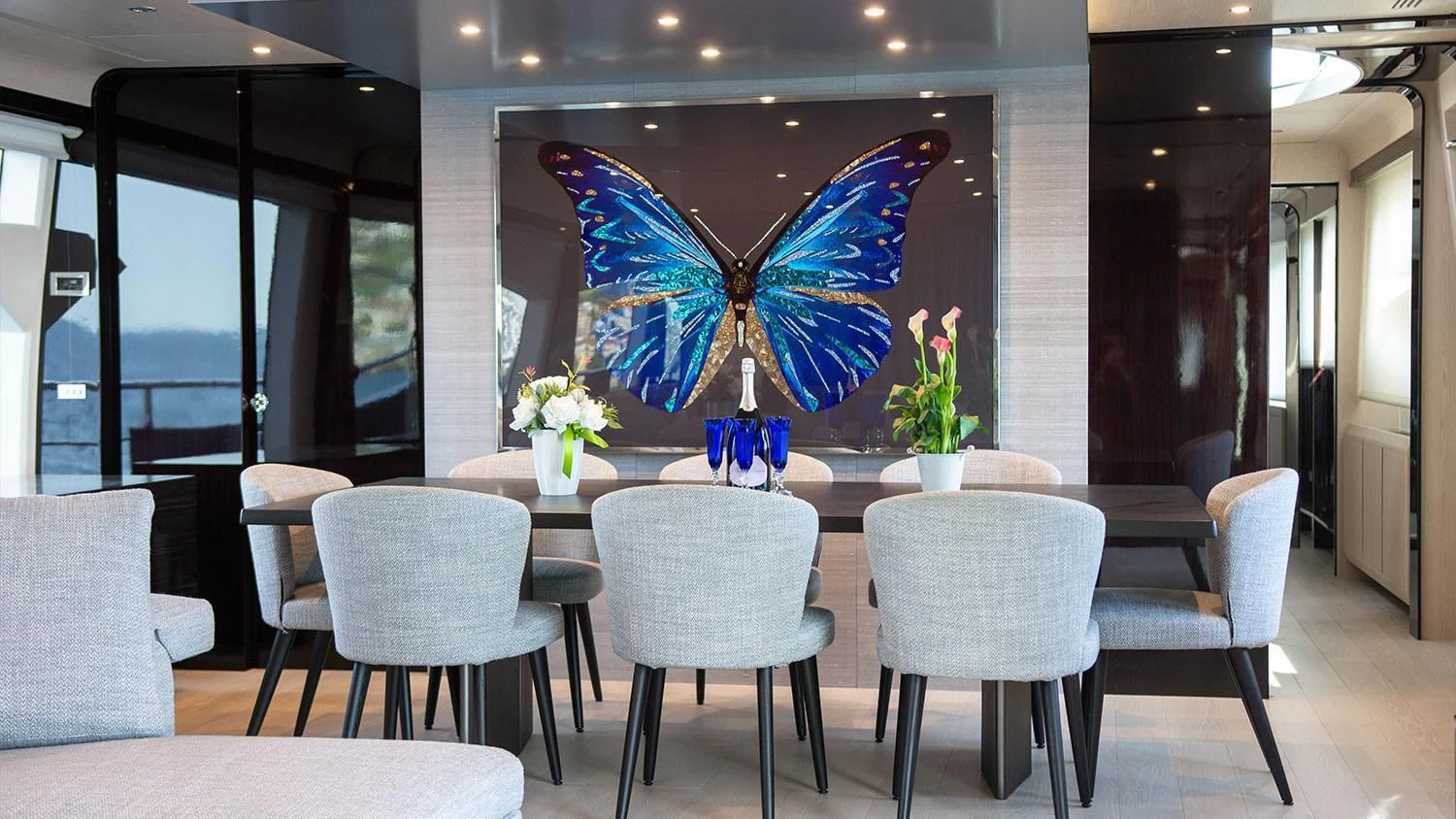 a large blue and white butterfly on a table in a room with chairs and a large blue and aboard SOLSTICE Yacht for Sale