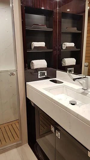 a bathroom with a shelf of towels aboard SOLSTICE Yacht for Sale