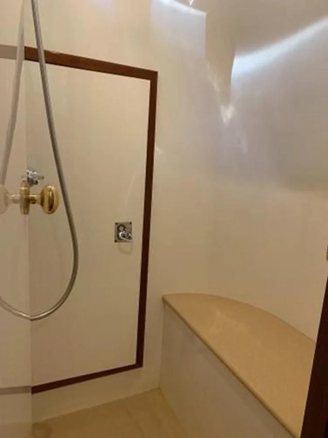a shower with a wooden door aboard TAKEN TIME II Yacht for Sale
