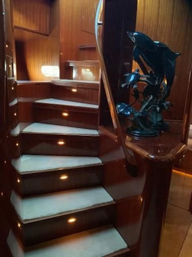 a wood staircase with a wood railing aboard TAKEN TIME II Yacht for Sale