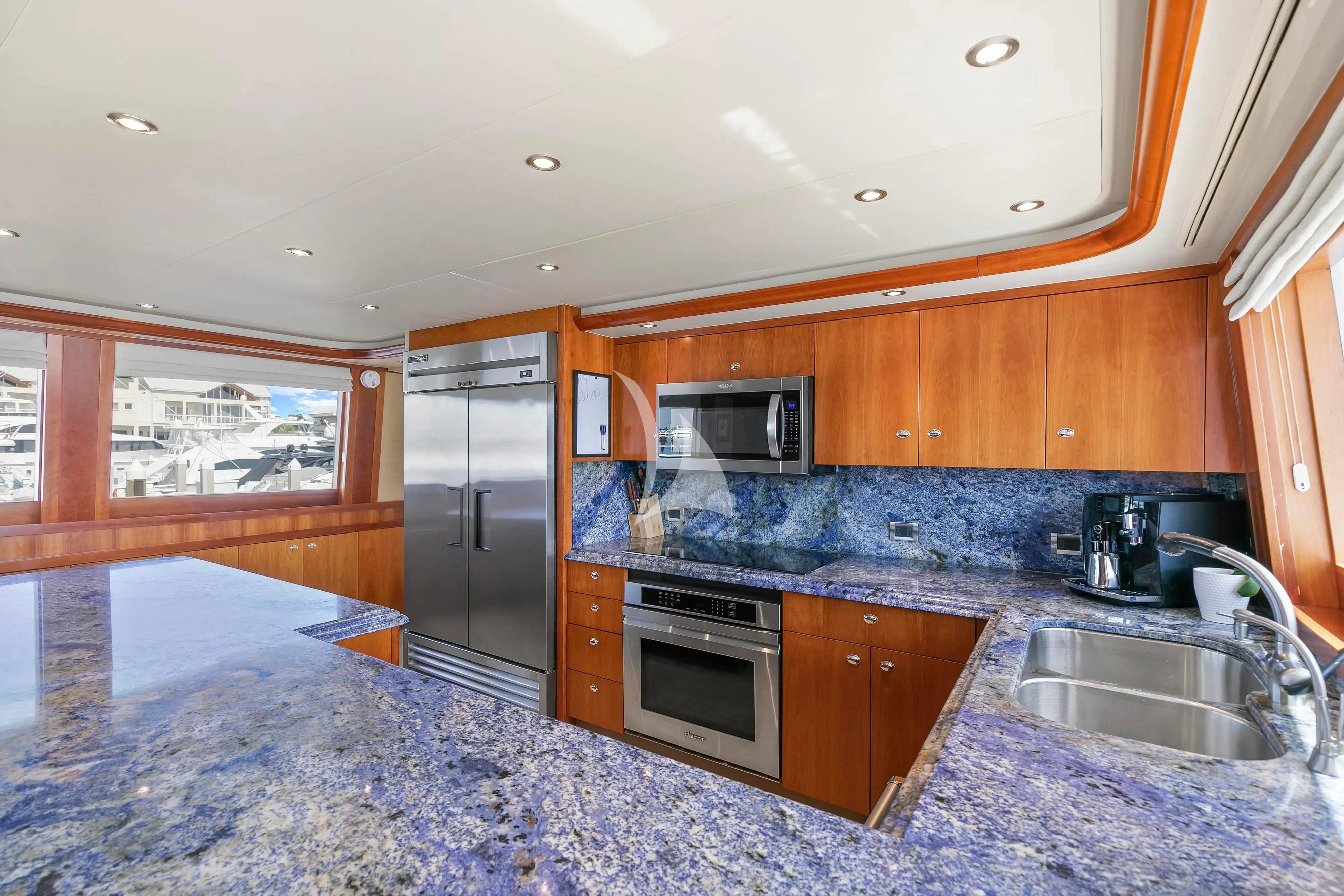 a kitchen with wooden cabinets aboard EDEN Yacht for Sale