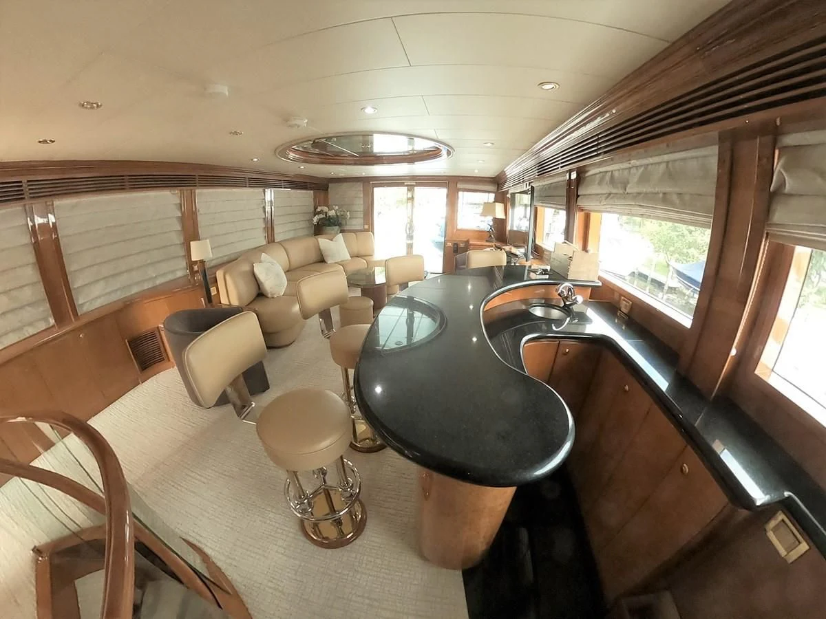 a large room with a bar and a table aboard SEAS THE DAY Yacht for Sale
