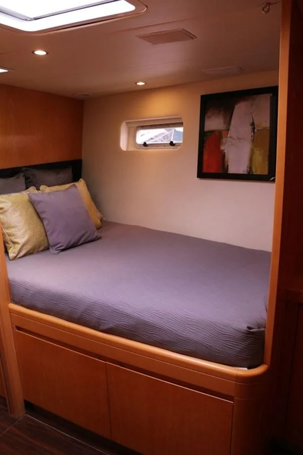 a bed with a blue comforter aboard LA LUNA Yacht for Sale