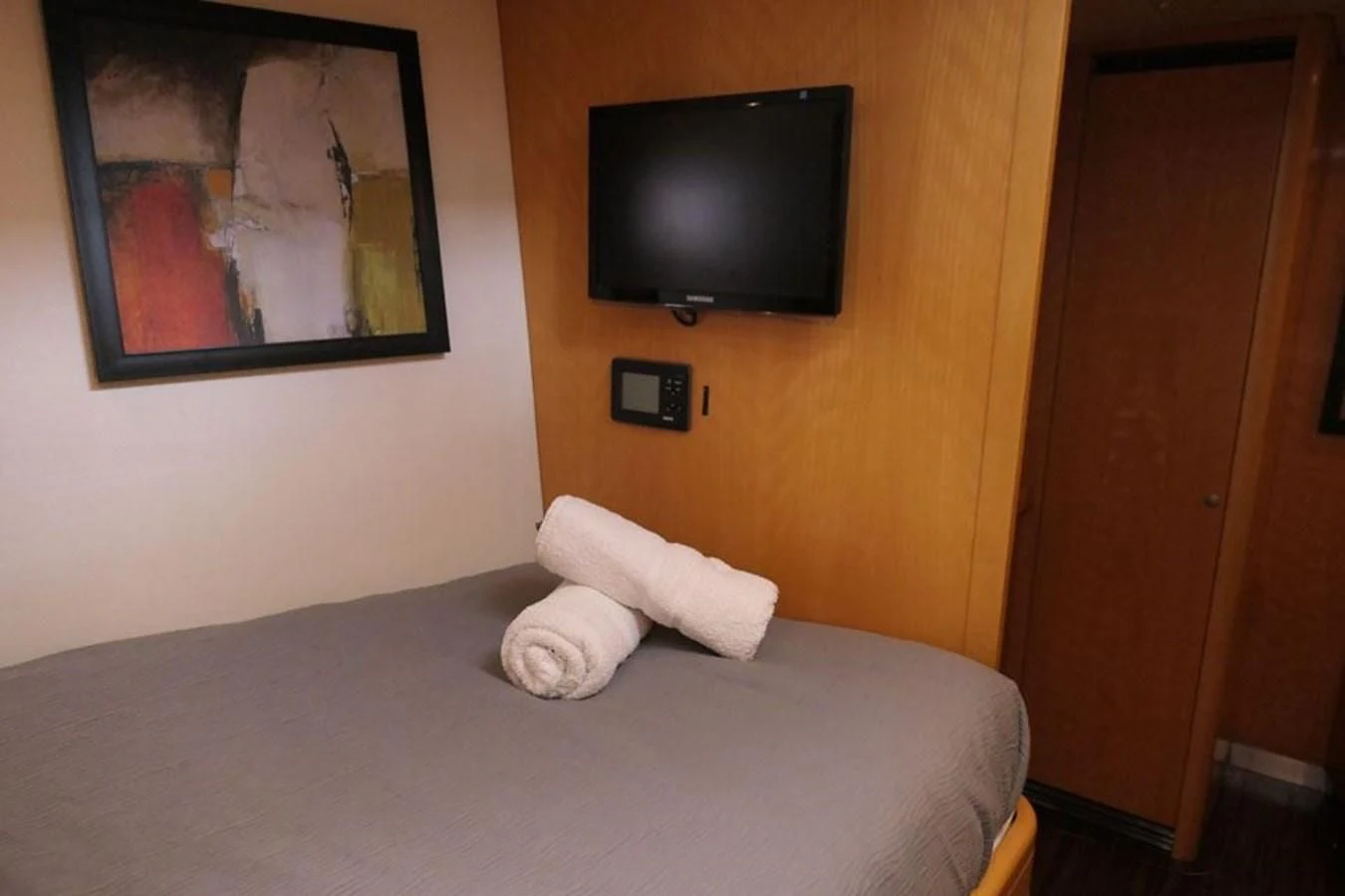 a bed with a tv on the wall aboard LA LUNA Yacht for Sale
