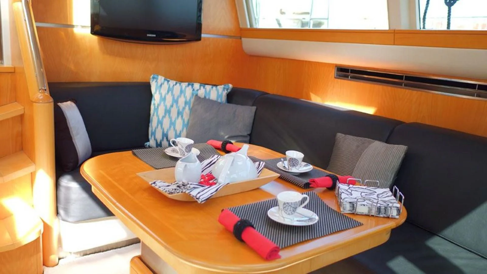 a coffee table with a red and white striped pillow and a red pen on it aboard LA LUNA Yacht for Sale