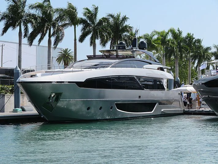 a white yacht docked at a tropical resort aboard IRON GRYPHON Yacht for Sale