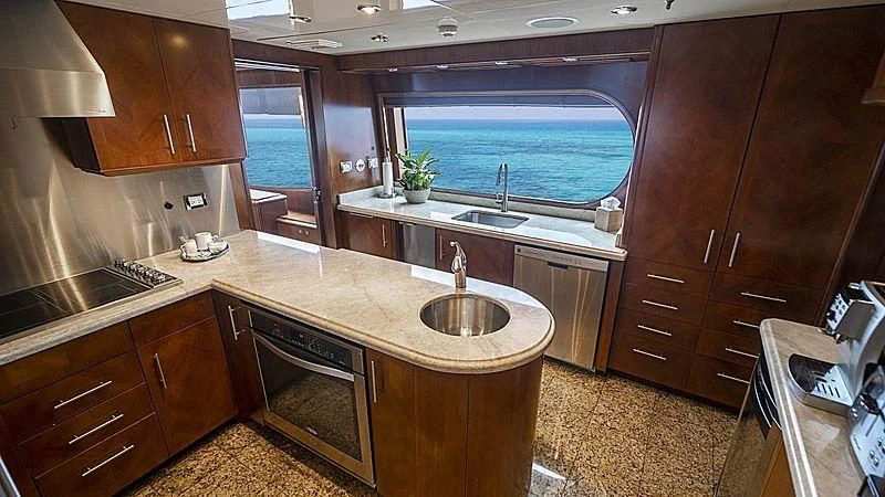 a kitchen with wooden cabinets aboard CAMILLE Yacht for Sale