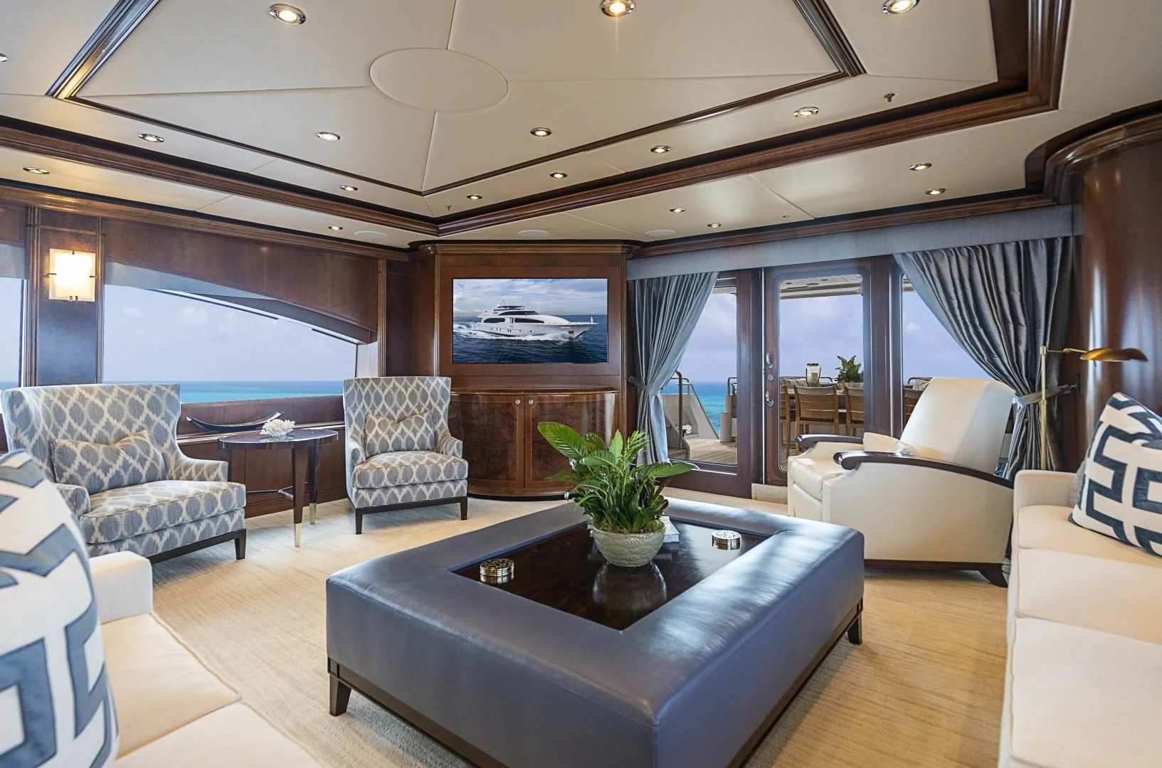 a living room with a large glass coffee table and a large window aboard CAMILLE Yacht for Sale
