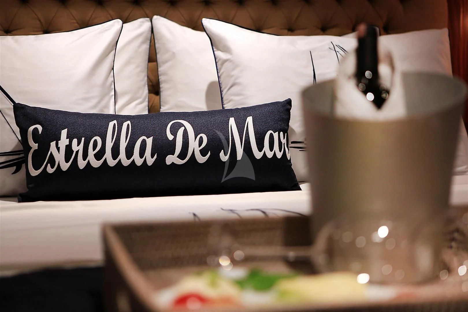 a white cup with a black straw on a table with a white pillow and a white pillow and aboard ESTRELLA DE MAR Yacht for Sale
