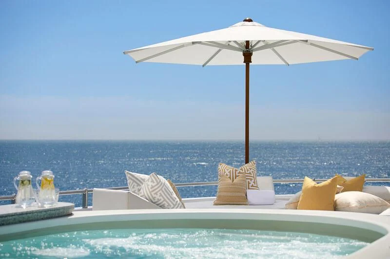 a pool with a umbrella and pillows aboard LA BLANCA Yacht for Sale