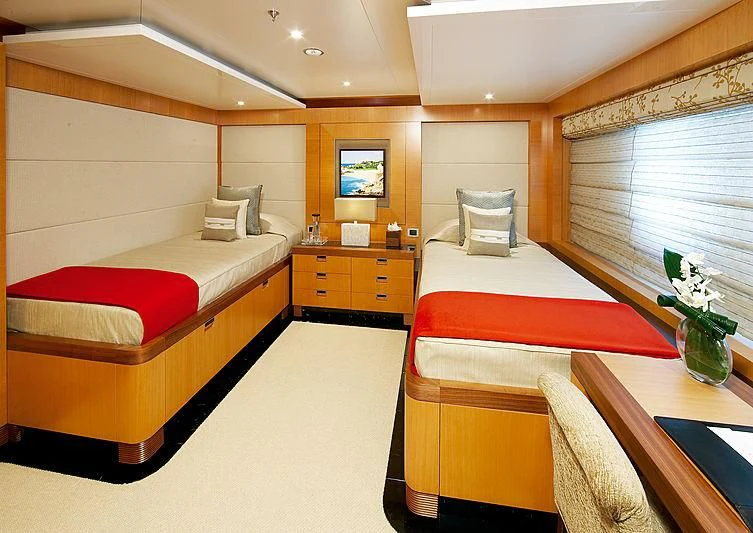 a room with beds and a desk aboard LA BLANCA Yacht for Sale
