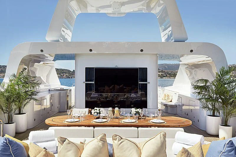 a large white house with a large outdoor table and chairs aboard LA BLANCA Yacht for Sale