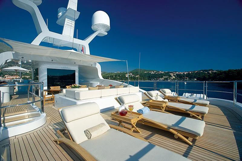 a deck with a large white boat on it and a building in the background aboard LA BLANCA Yacht for Sale