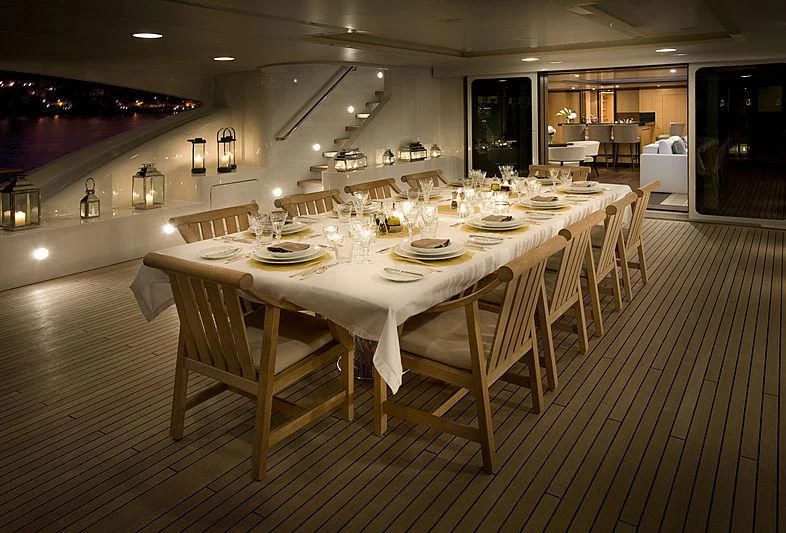 a large dining table with white chairs aboard LA BLANCA Yacht for Sale