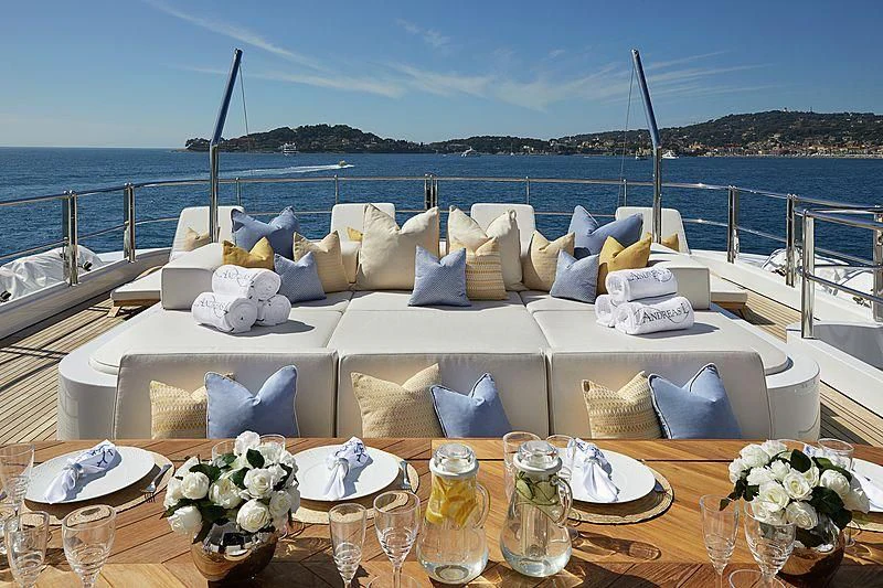 a white bed with white pillows and flowers on it aboard LA BLANCA Yacht for Sale