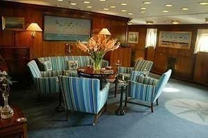 a room with a couch and a table and chairs aboard DANNEBROG Yacht for Sale