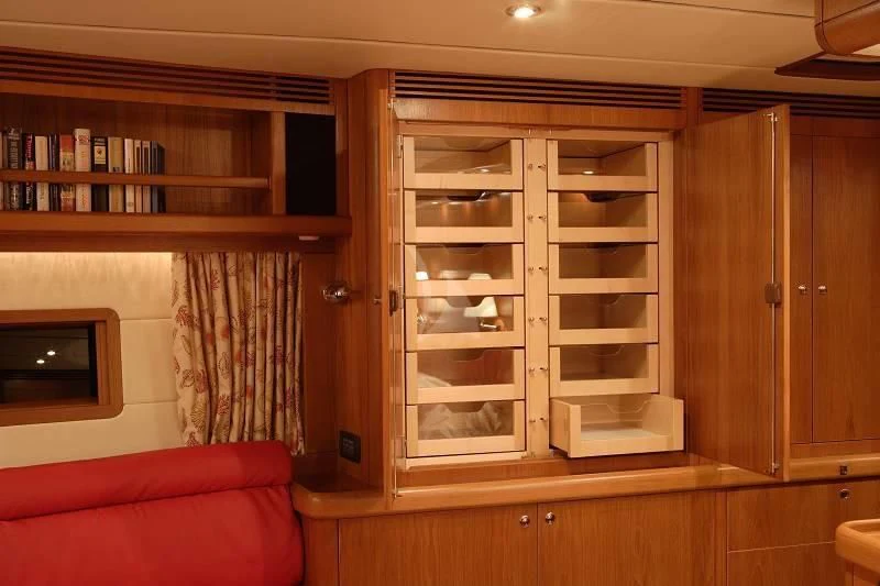 a room with a bookcase and a shelf with books aboard STARFALL Yacht for Sale