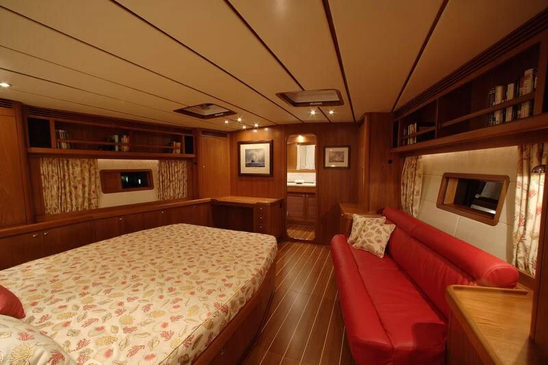 a bedroom with a bed and a couch aboard STARFALL Yacht for Sale