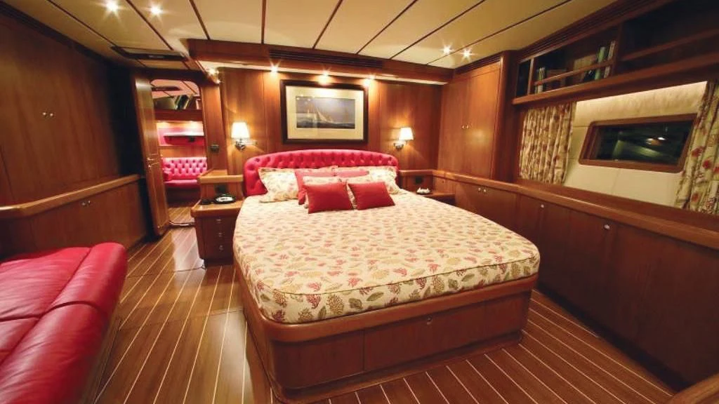 a room with a bed and a red couch aboard STARFALL Yacht for Sale