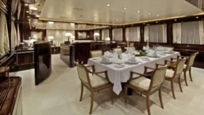 a large room with tables and chairs aboard O'RION Yacht for Charter