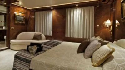 a room with a bed and a chair aboard O'RION Yacht for Charter