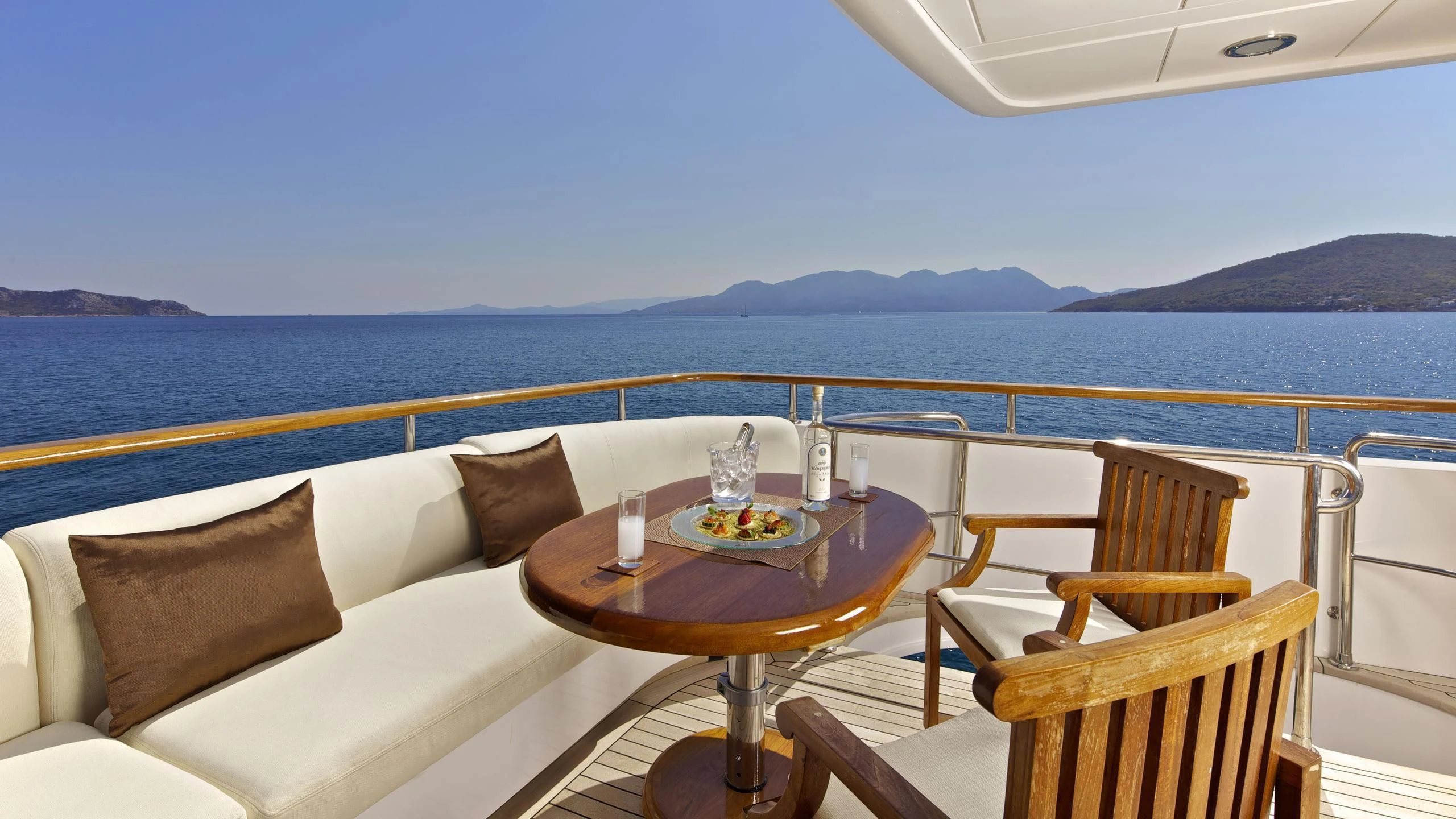 a table on a balcony overlooking the ocean aboard O'RION Yacht for Charter