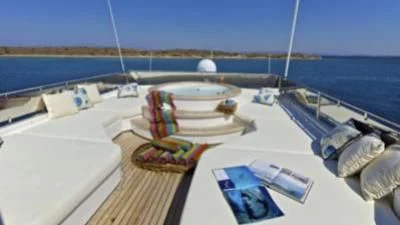 a large white lounge chair on a deck overlooking a large body of water aboard O'RION Yacht for Charter