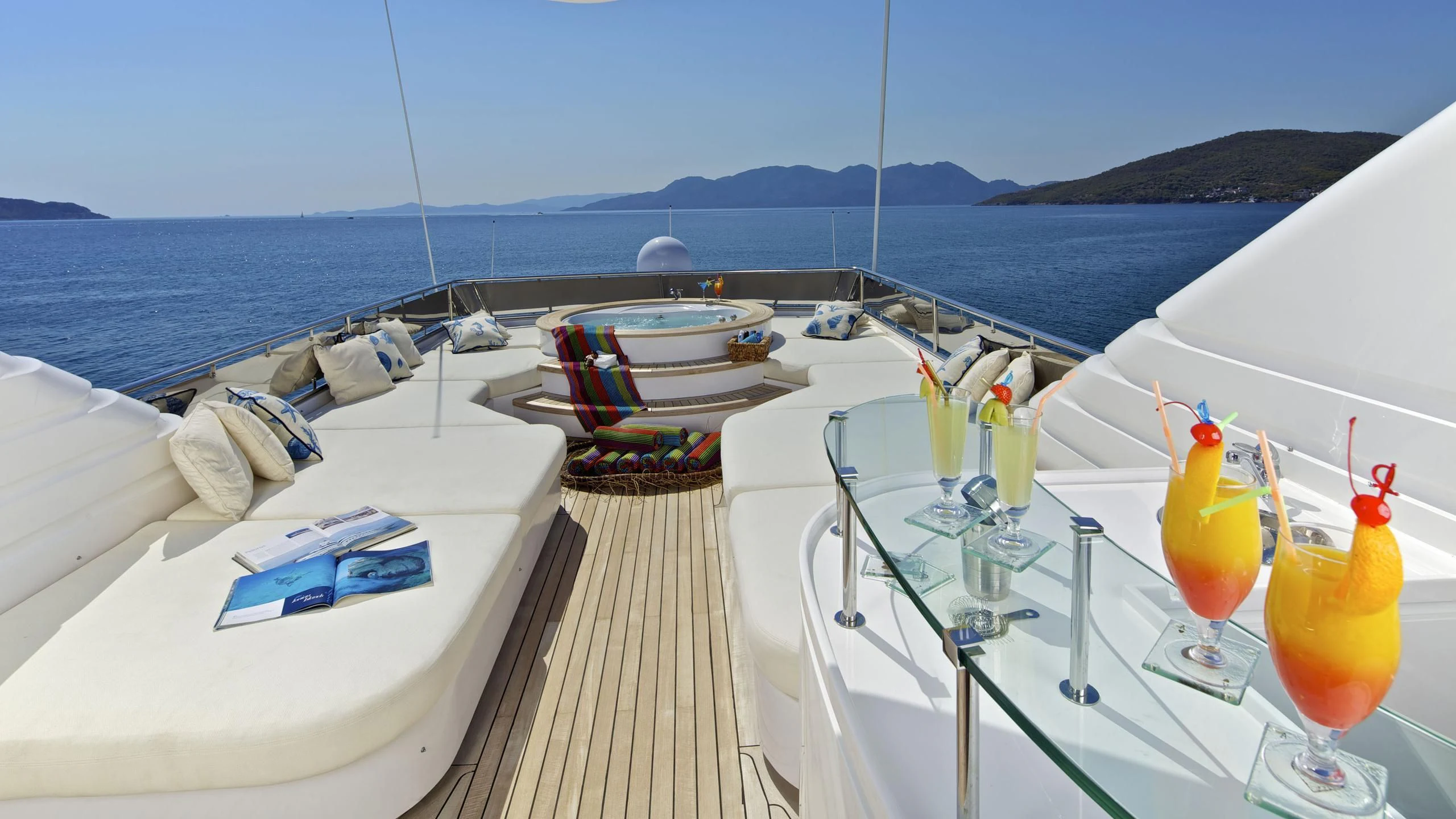 a table with drinks on it by the beach aboard O'RION Yacht for Charter