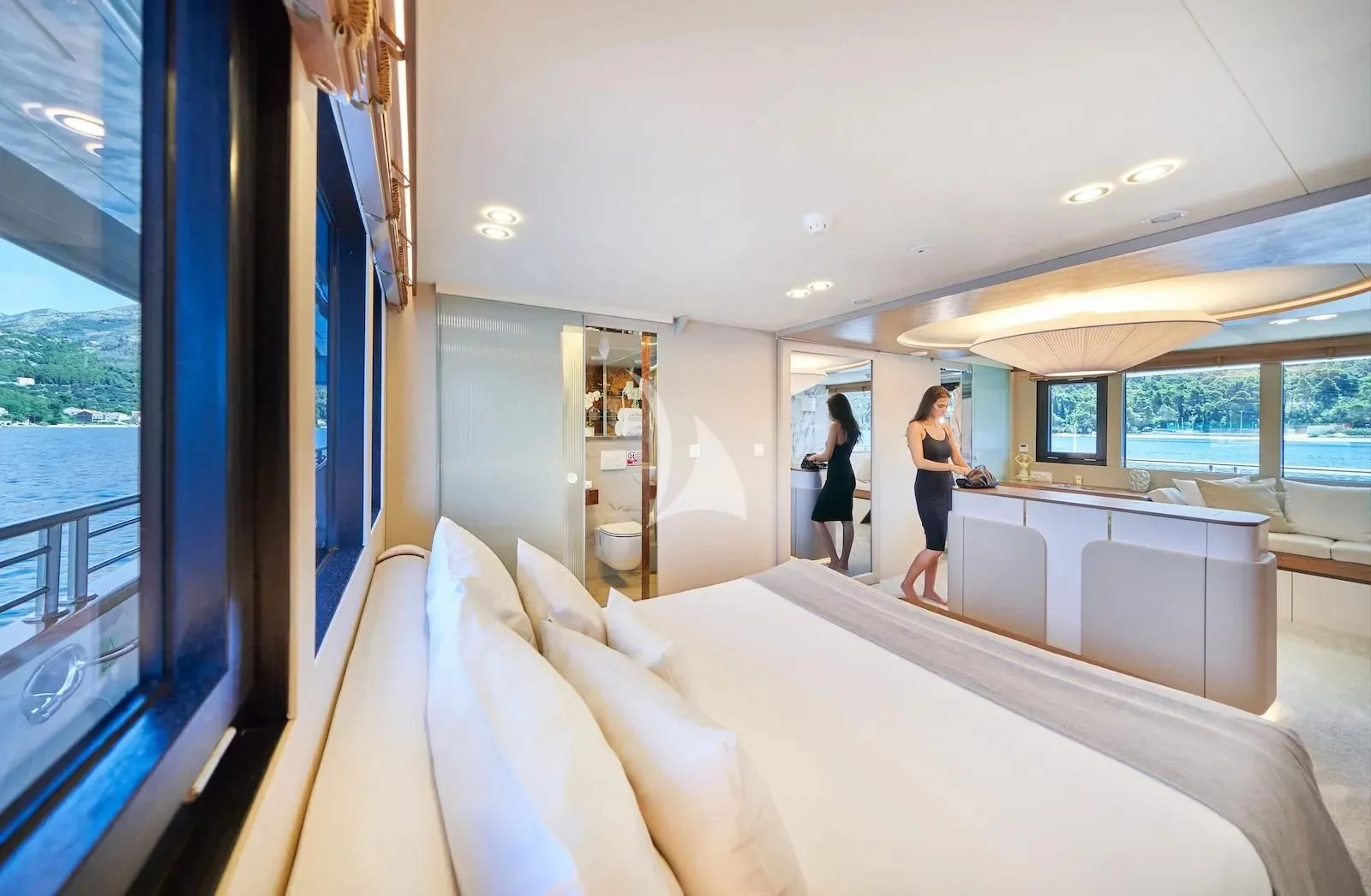 a room with a bed and a couple of women walking in it aboard AETERNA Yacht for Sale