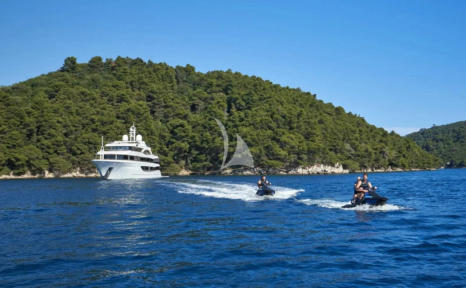 a couple of people on jet skis in the water with a boat in the background aboard AETERNA Yacht for Sale