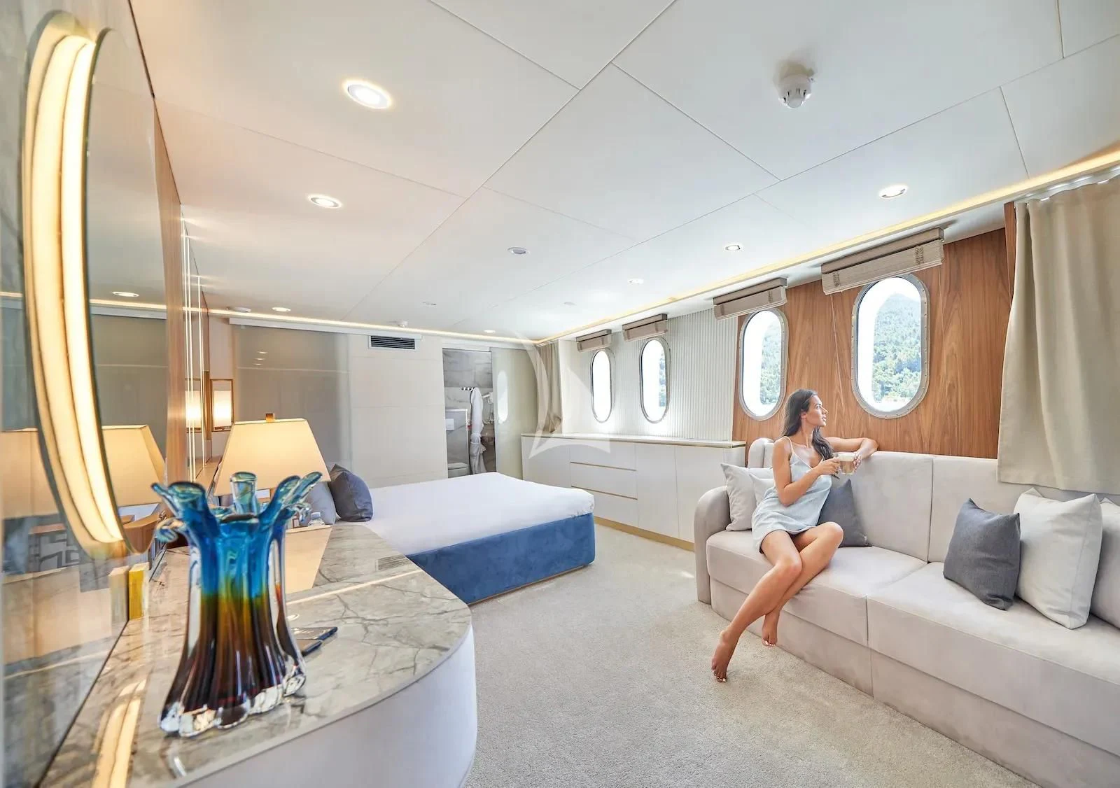 a person sitting on a couch in a room with a vase of flowers aboard AETERNA Yacht for Sale