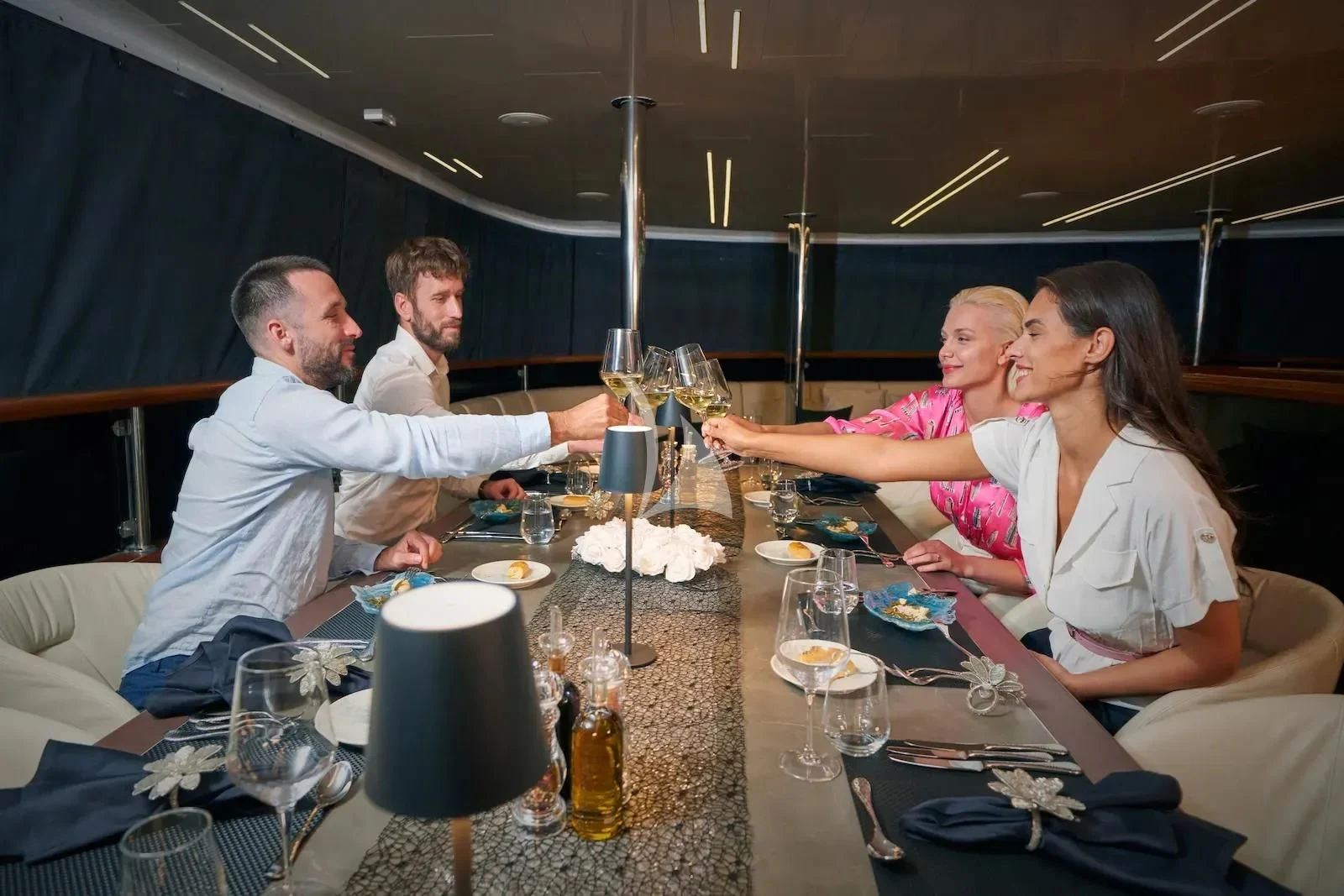 a family sits around a table aboard AETERNA Yacht for Sale