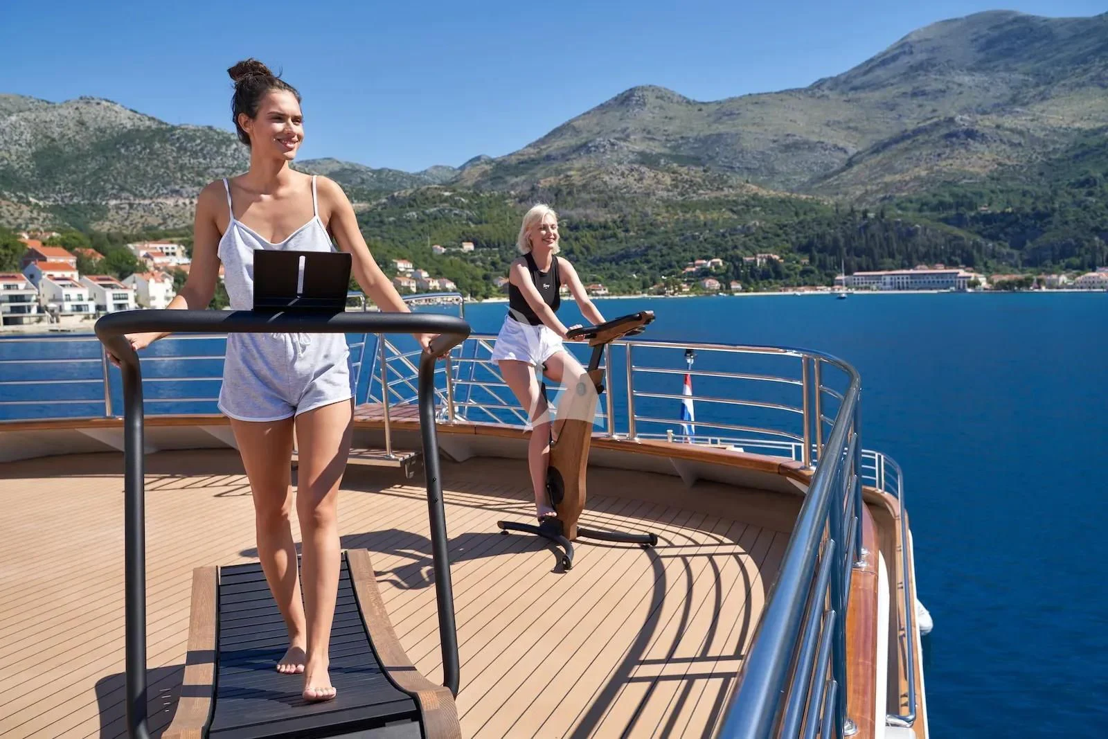 two women standing on a deck overlooking a body of water aboard AETERNA Yacht for Sale