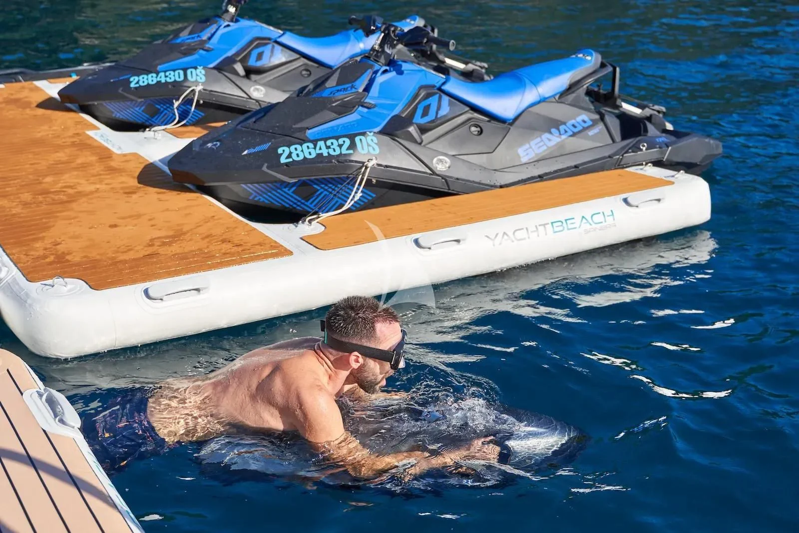 a man in the water with a boat in the background aboard AETERNA Yacht for Sale