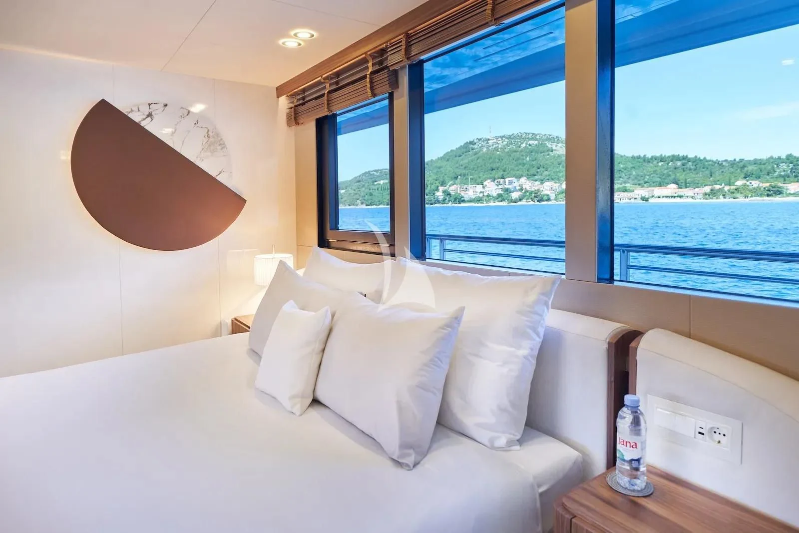 a bed with pillows and a window aboard AETERNA Yacht for Sale