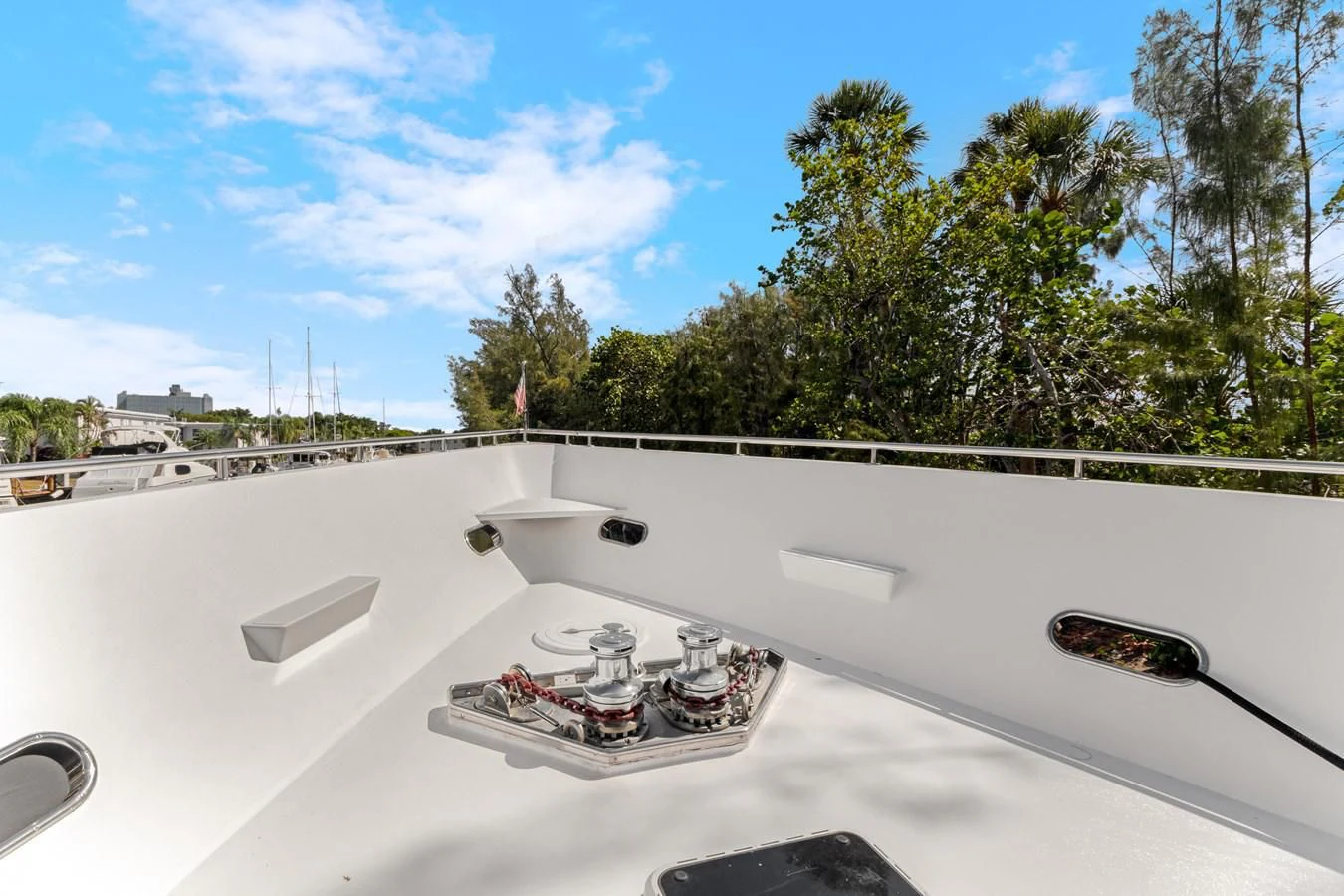 a white car with a door open on a white surface with trees and blue sky and clouds in aboard MARY KATHLENE Yacht for Sale