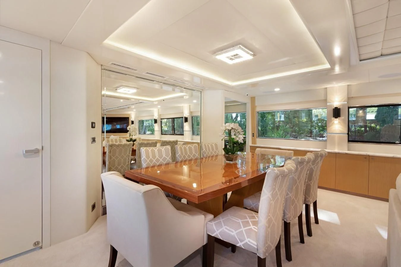 a dining table and chairs in a room with a large window aboard MARY KATHLENE Yacht for Sale