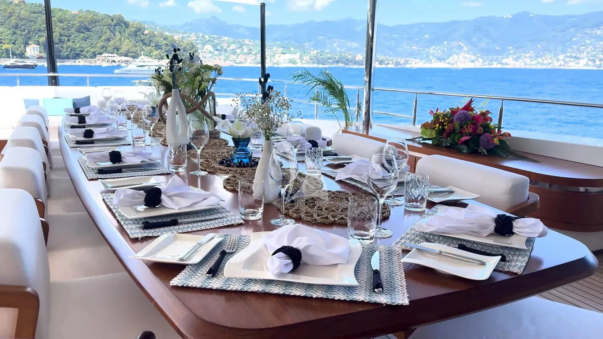 a table set with a view of the ocean and mountains aboard ETERNAL SPARK Yacht for Sale