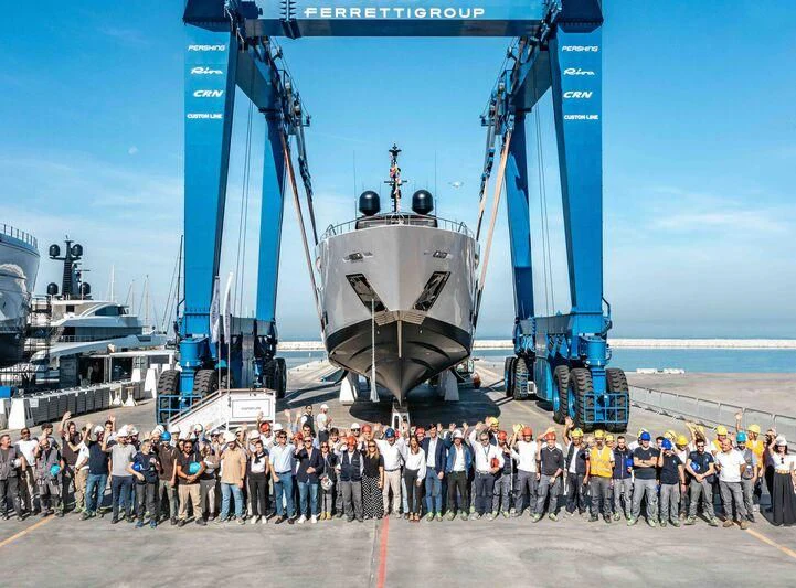 a group of people posing for a photo in front of a large ship aboard CARMA Yacht for Sale