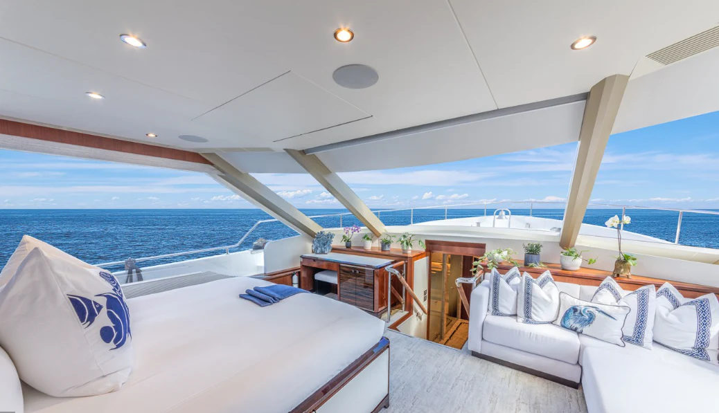 a room with a bed and a table and a view of the ocean aboard DRINKABILITY Yacht for Sale