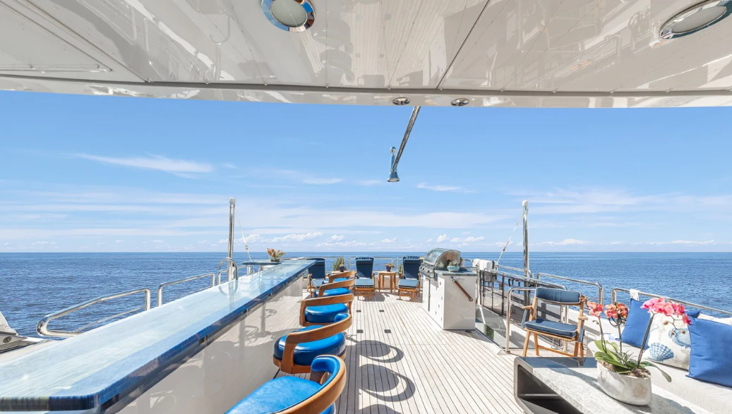 a deck with chairs on it and a body of water in the background aboard DRINKABILITY Yacht for Sale
