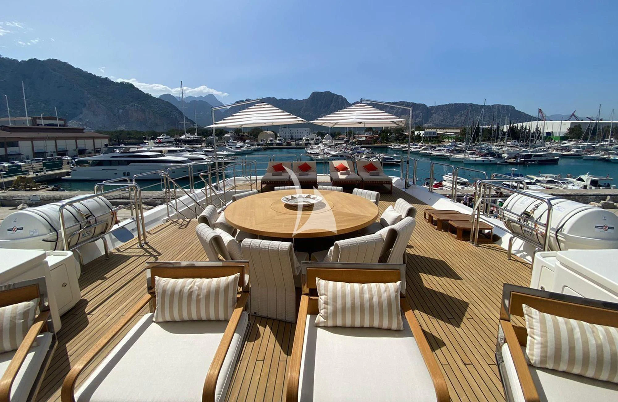a deck with chairs and tables on it by a body of water aboard LADY I Yacht for Charter