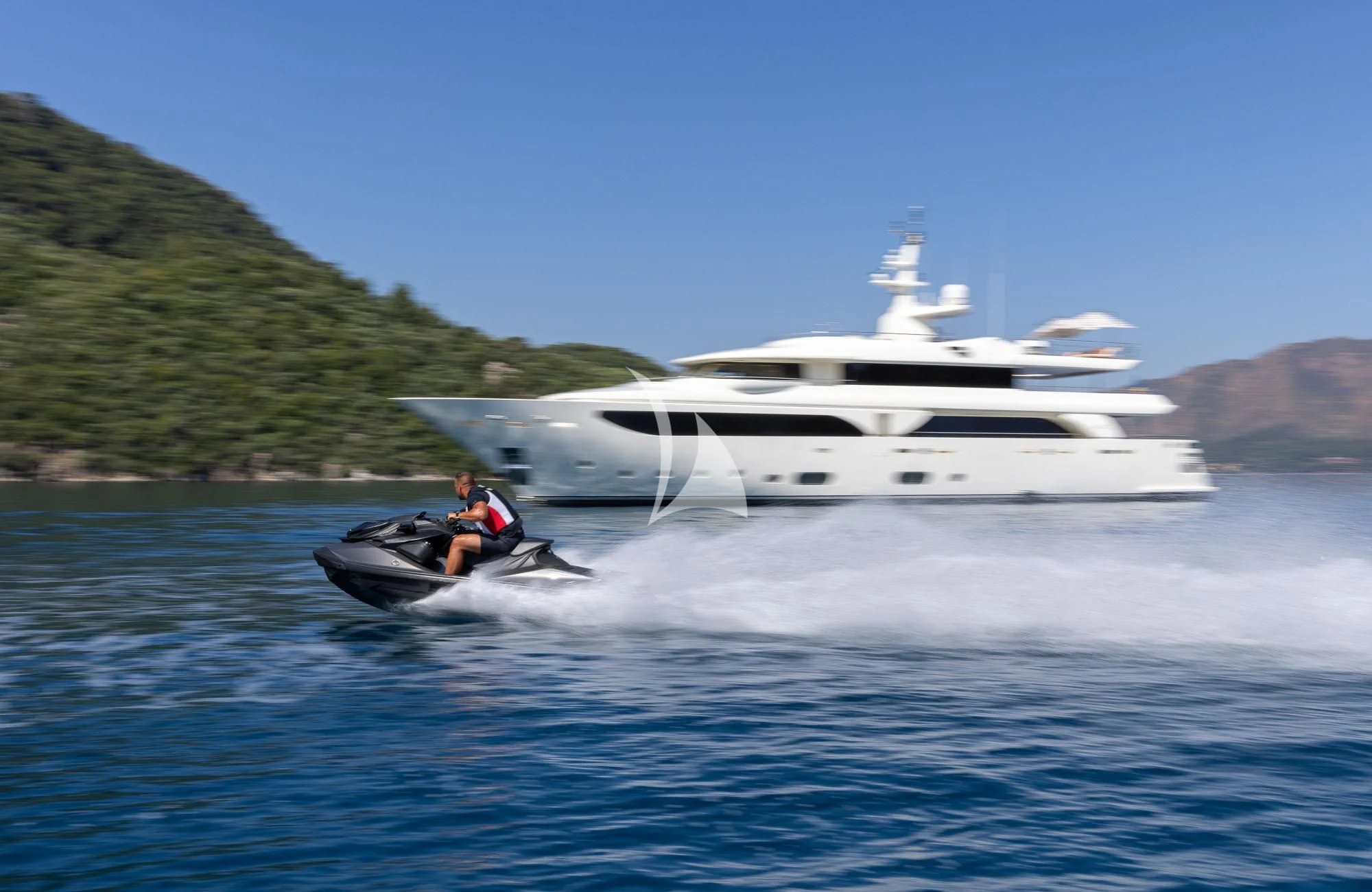 a person on a boat in the water with a boat in the background aboard LADY I Yacht for Charter