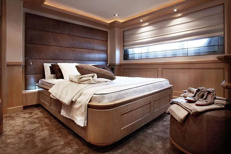 a room with a bed and a couple of suitcases aboard LADY I Yacht for Charter