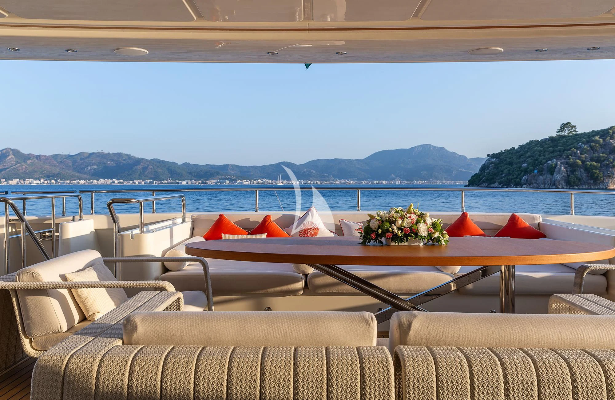 a table with chairs and plants on it by a body of water aboard LADY I Yacht for Charter