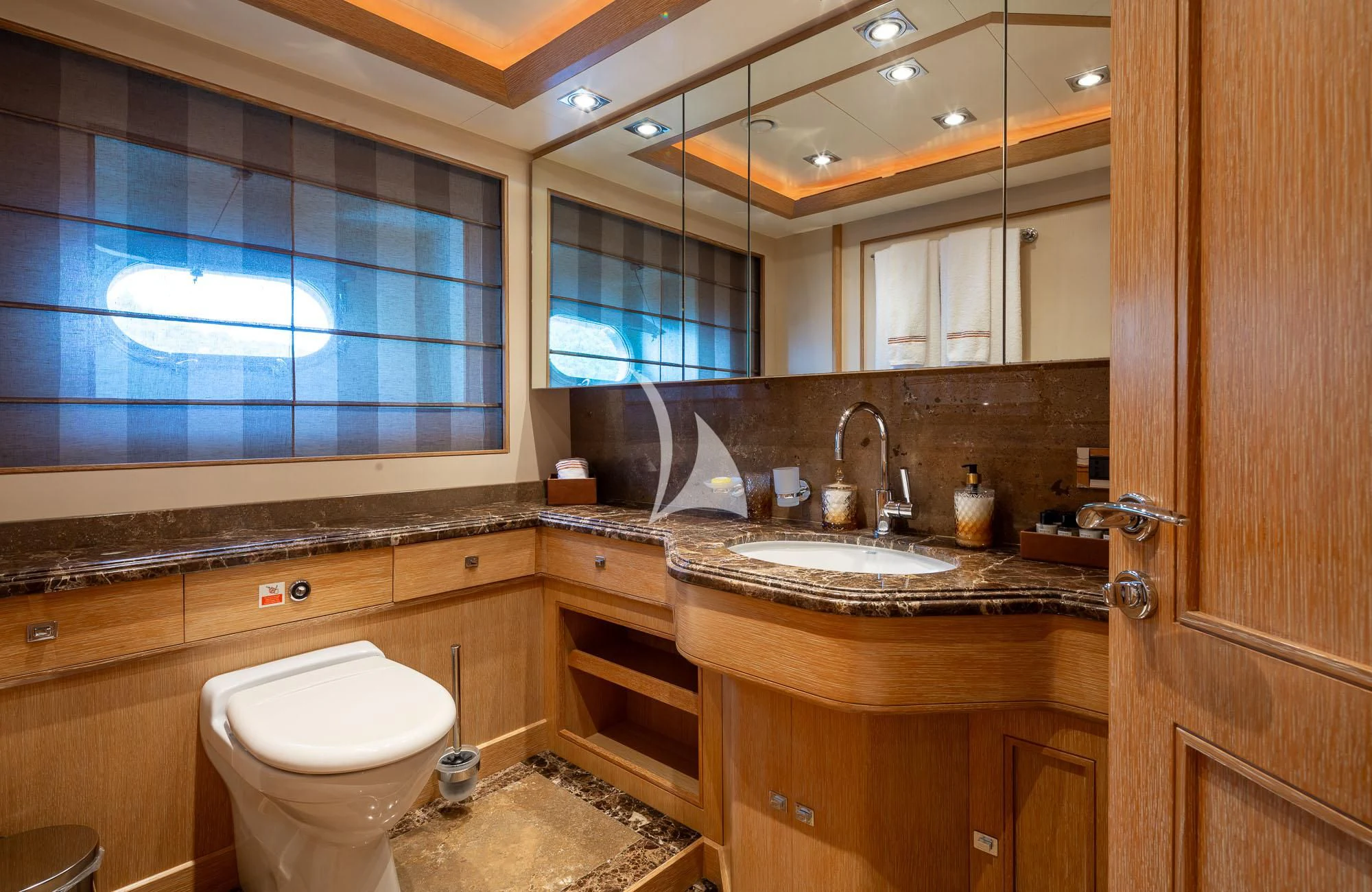 a bathroom with a sink toilet and a mirror aboard LADY I Yacht for Charter